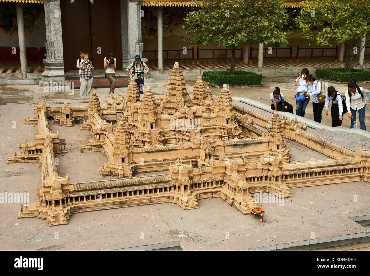 PHNOM PENH, CAMBODIA - FEBRUARY 21, 2013: Tourists are taking pictures of a miniature model of temple of Angkor Wat in the Royal Palace Stock Photo