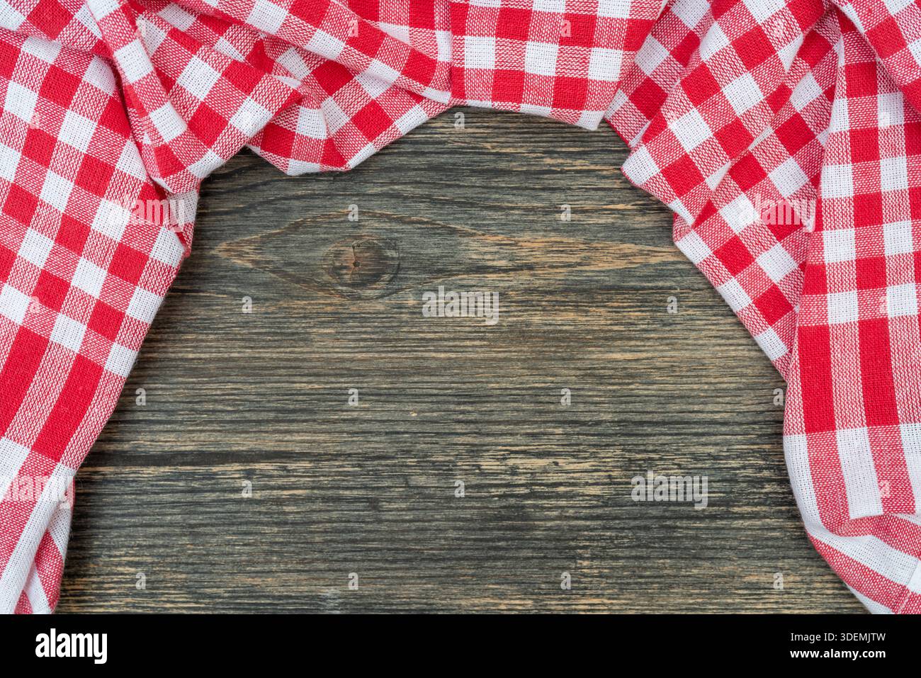 Red checkered towel on the kitchen table. Wooden table background. Stock Photo