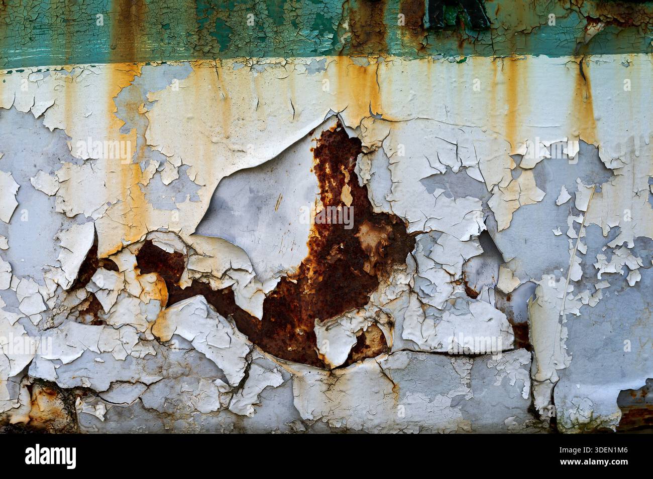 Close up of peeling paint and rust creating a grunge texture on a metallic surface, showcasing decay and the passage of time Stock Photo