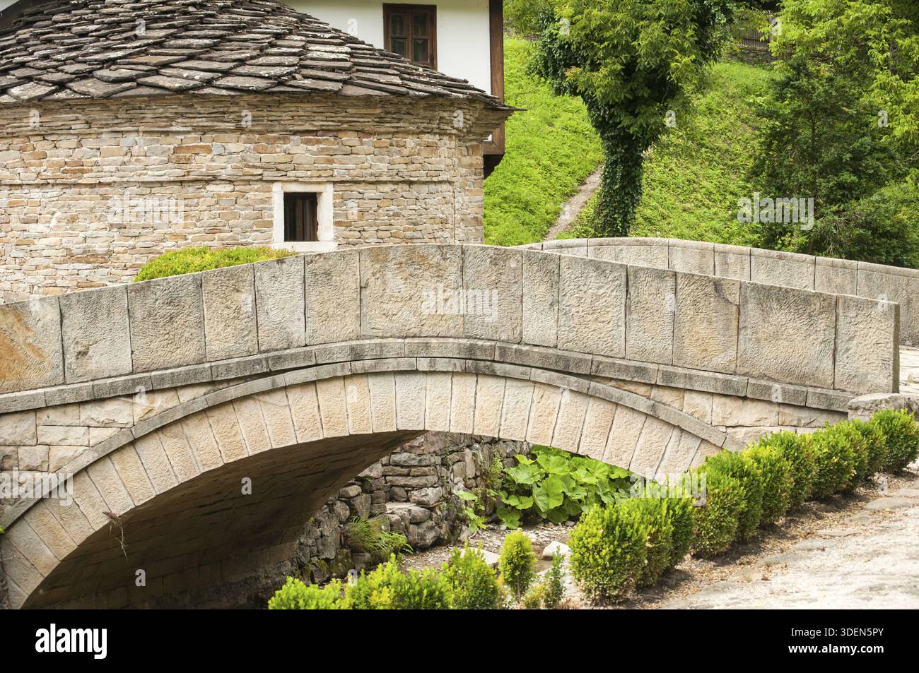 Old stone country house and stone vaulted bridge over small river Stock ...