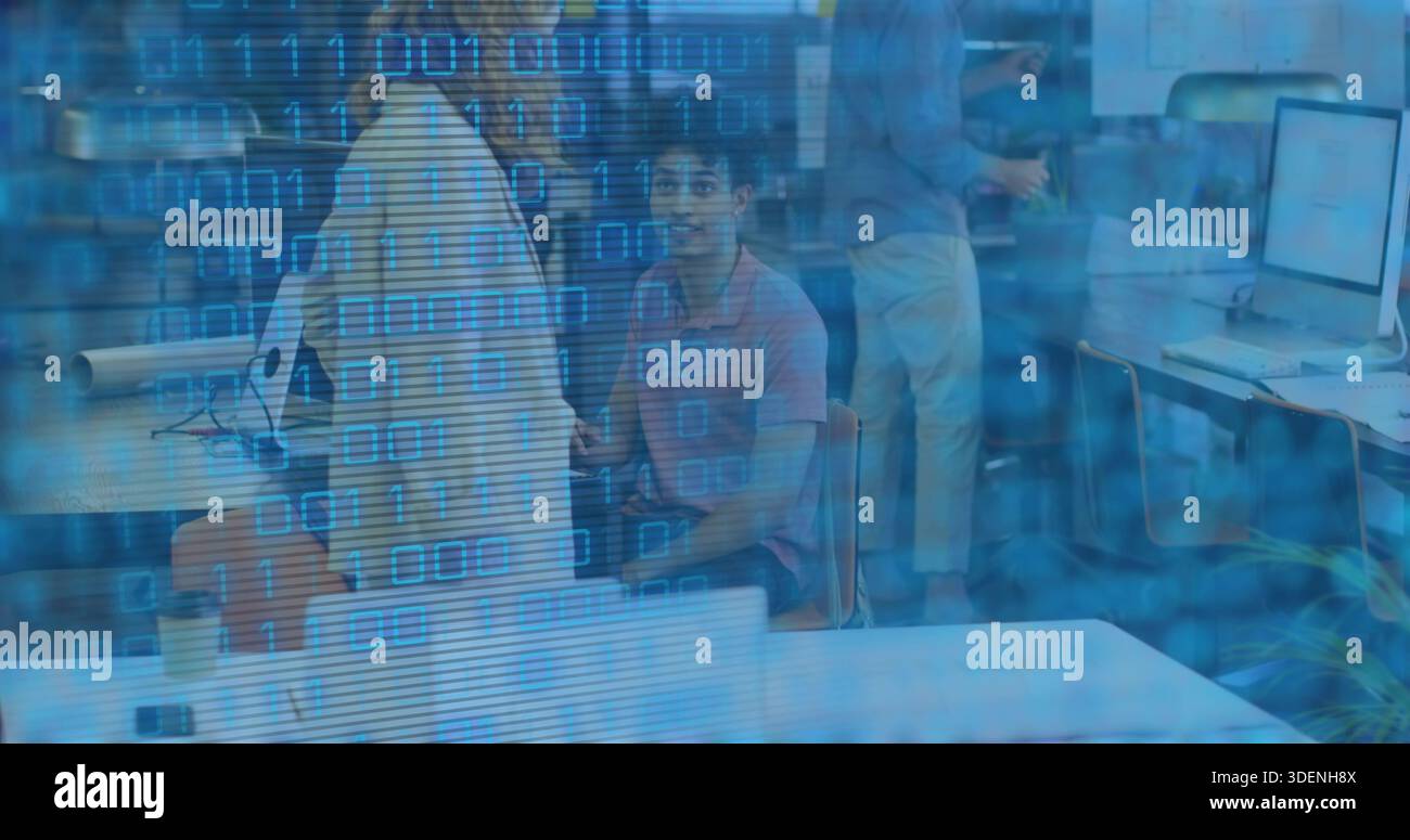 Sitting man in pink polo looking at camera, shared workspace with coffee cup and binary overlay Stock Photo