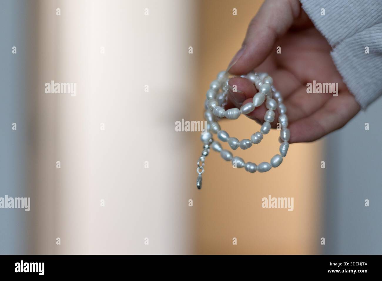 Woman holding elegant white pearl necklace Stock Photo