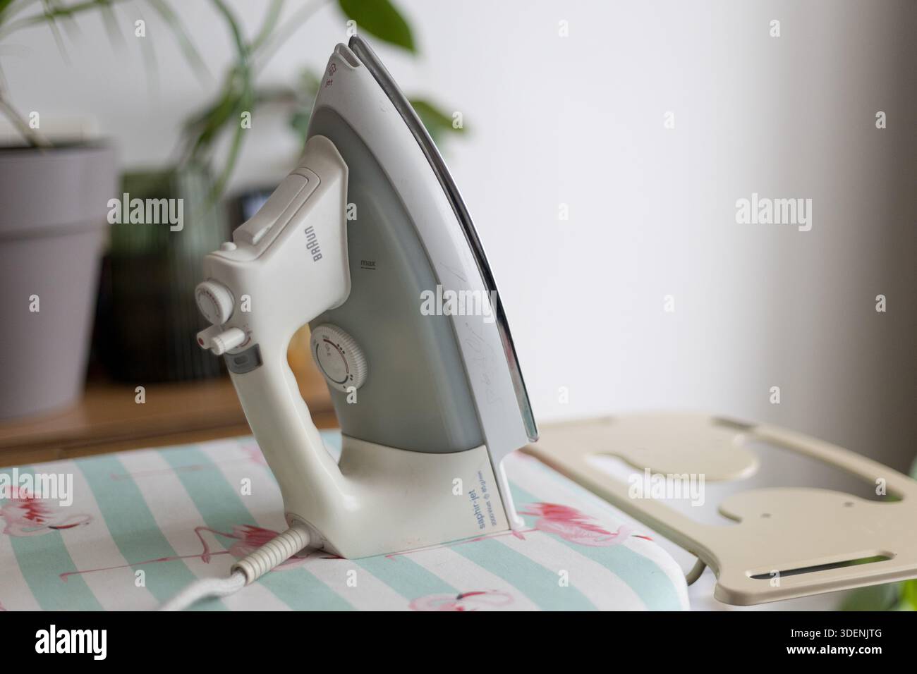 Modern steam iron on ironing board Stock Photo