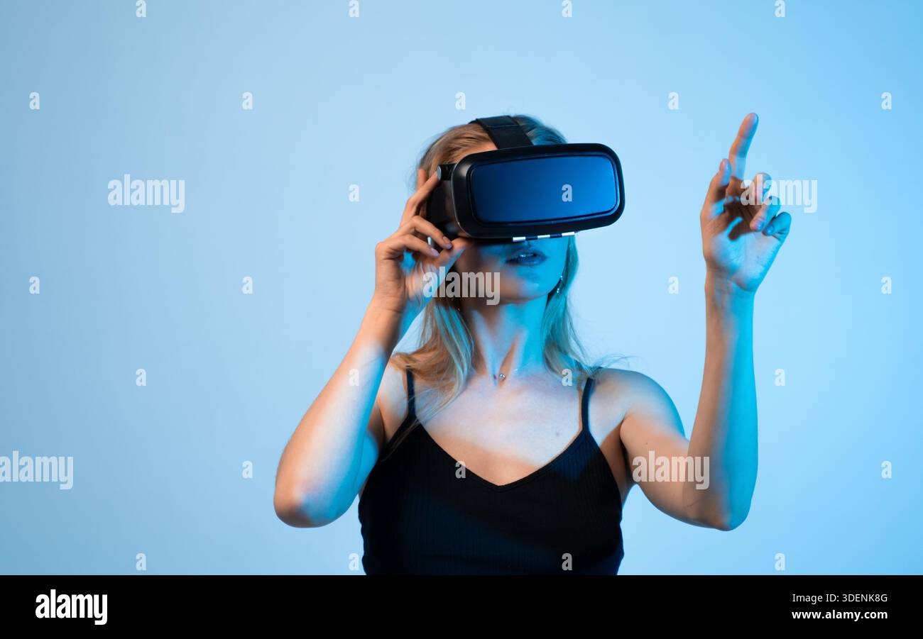 Woman using virtual reality headset and pointing at digital interface, VR design process and interactive user experience Stock Photo