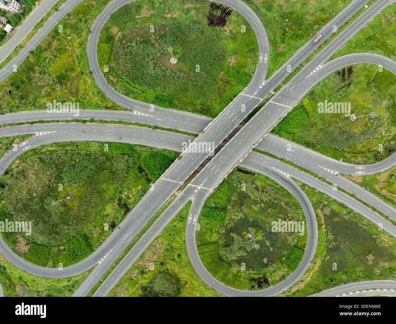 Aerial view of a cloverleaf interchange with looping ramps connecting ...