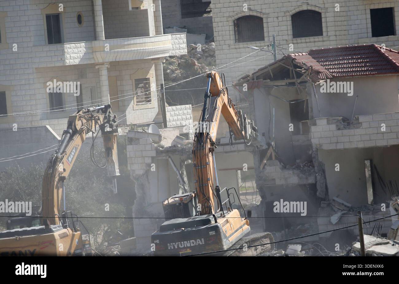 Israeli military bulldozers demolish a house in the Al-Ta'awun ...