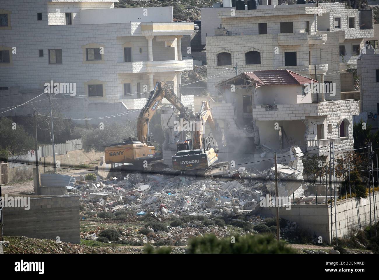 Israeli military bulldozers demolish a house in the Al-Ta'awun ...