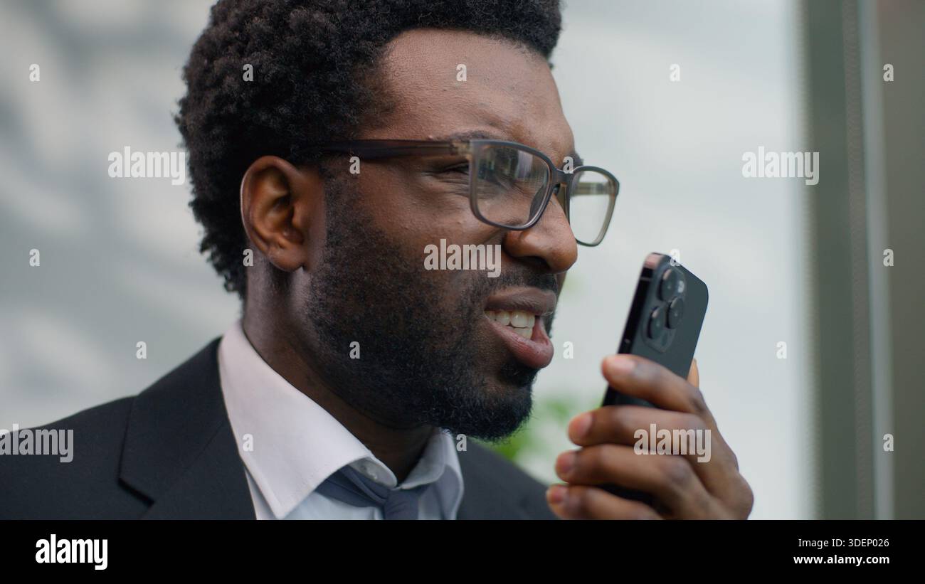 Angry stressed authority African American man business guy male businessman in office yelling loud in mobile phone conflict smartphone call blaming Stock Photo