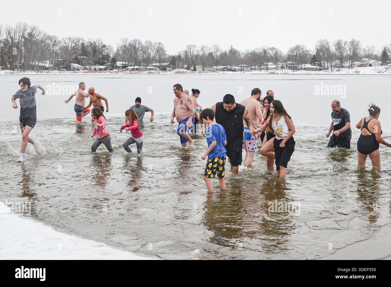 New Year's Day Polar Plunge participants dash through an icy Stone Lake ...