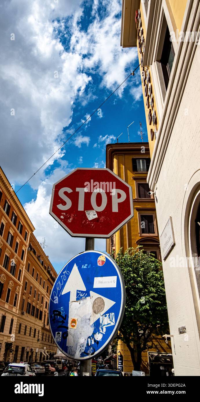 Stop sign and one-way traffic sign mounted on a narrow European city ...