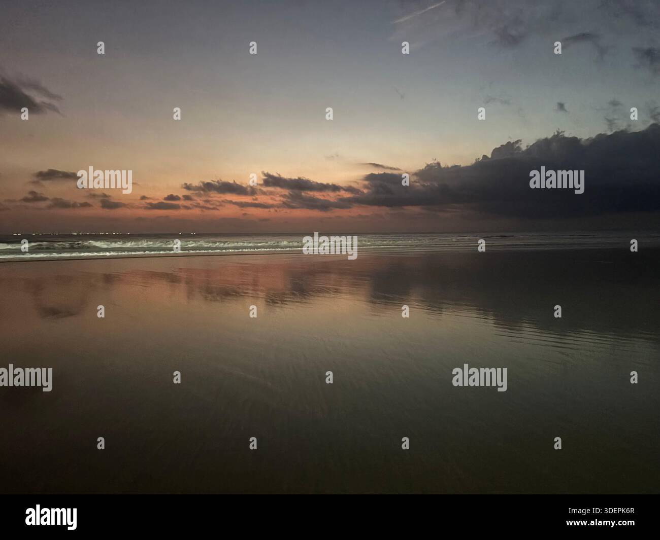 Serene beach at sunrise or sunset in Canggu, Bali with colorful sky and gentle ocean waves - Smartphone Captured Stock Image