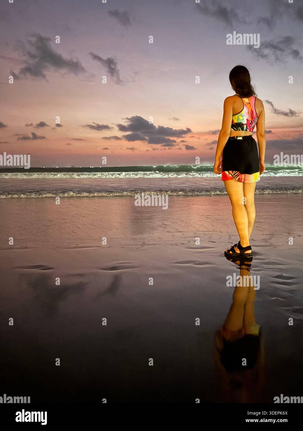 Serene beach at sunrise or sunset in Canggu, Bali with colorful sky and gentle ocean waves - Smartphone Captured Stock Image