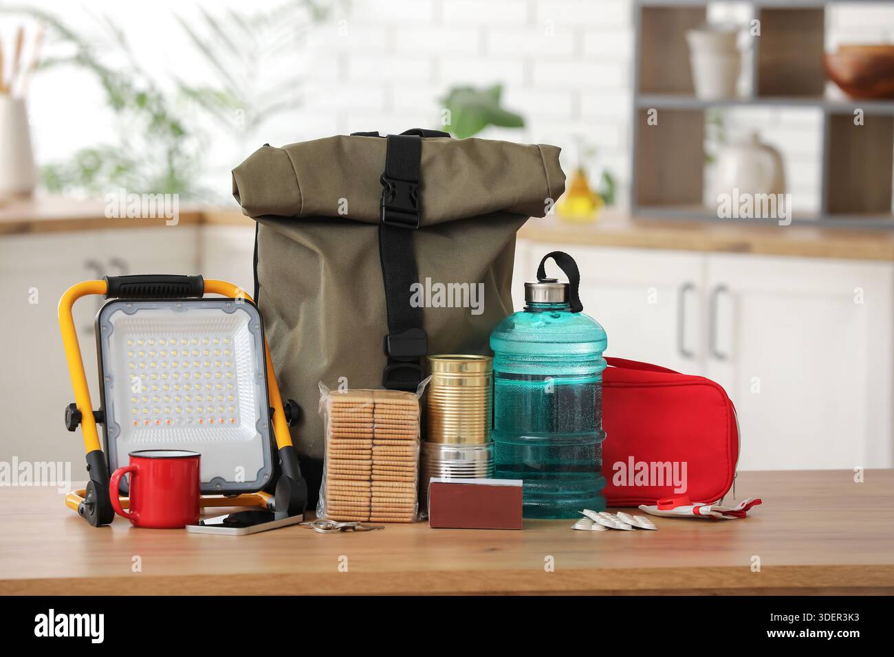 Emergency backpack with necessities on table in kitchen Stock Photo