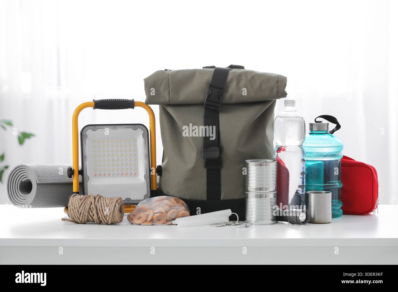 Emergency backpack with necessities on table in room Stock Photo