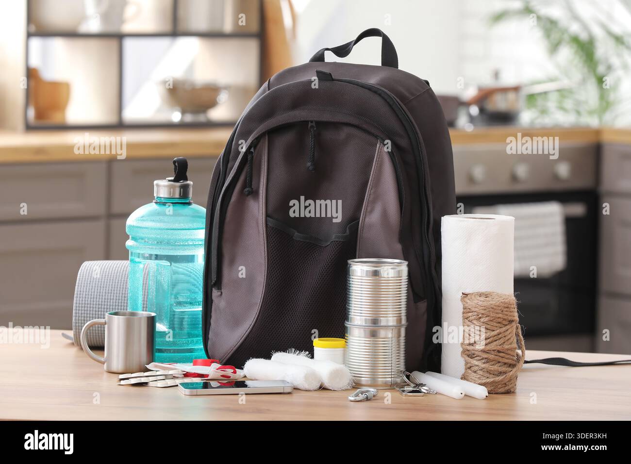 Emergency backpack with necessities on table in kitchen Stock Photo