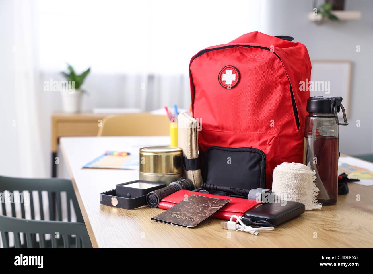 Emergency backpack with necessities on table in classroom Stock Photo