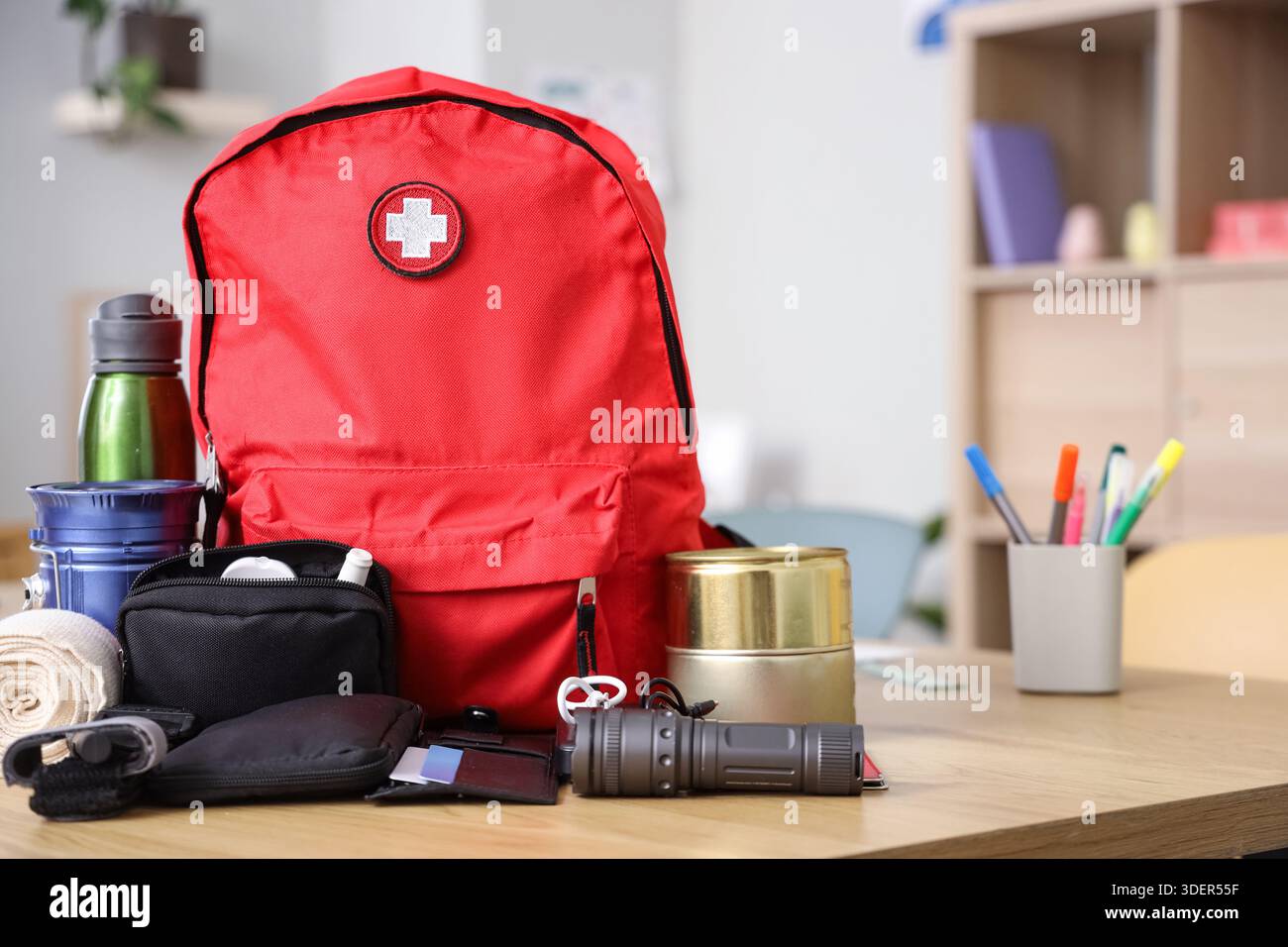 Emergency backpack with necessities on table in classroom Stock Photo