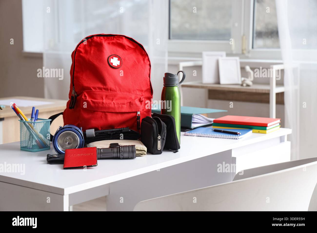 Emergency backpack with necessities on table in classroom Stock Photo