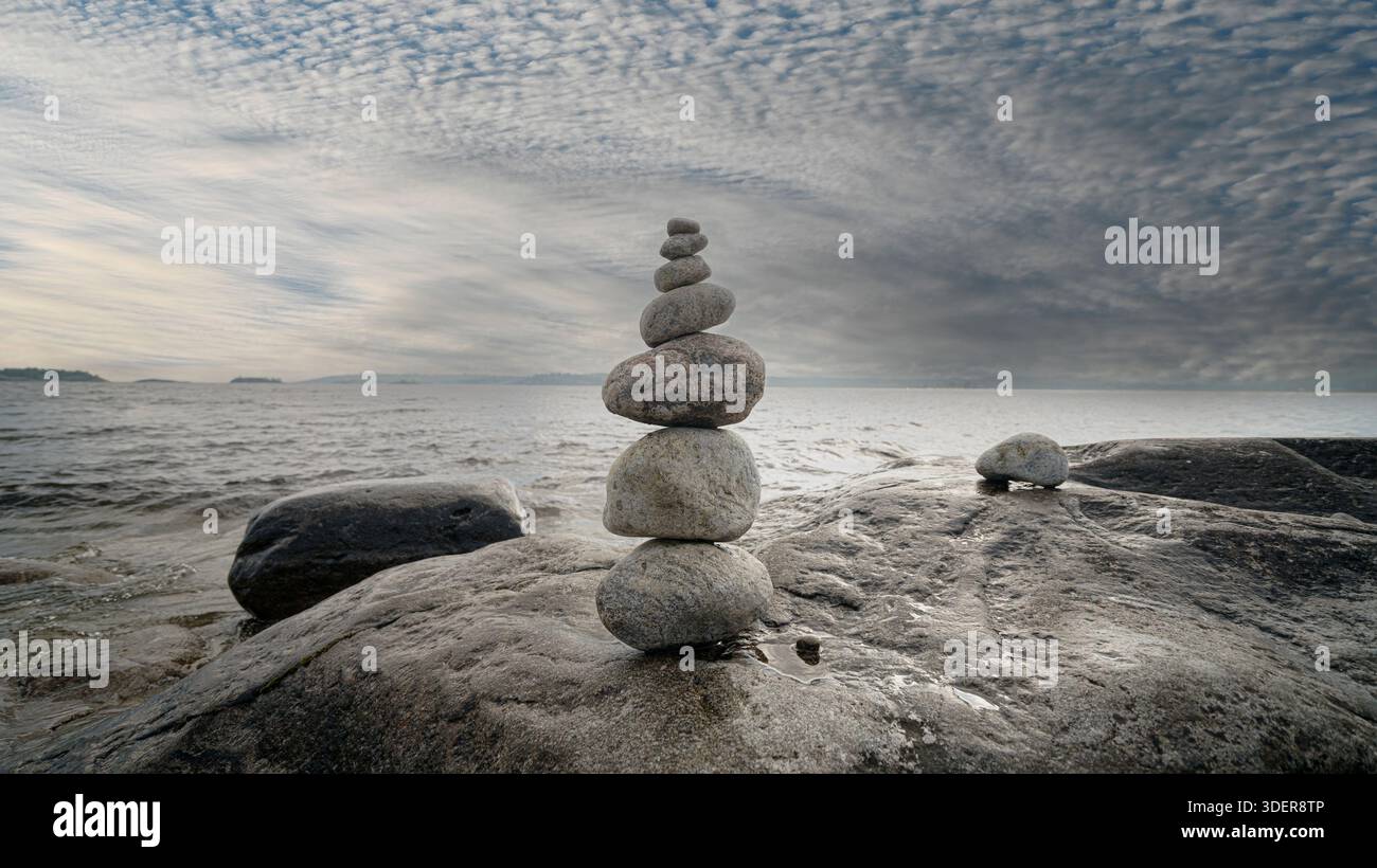 Stacked Rocks balancing, stacking with precision. Stone tower on the shore. Stock Photo