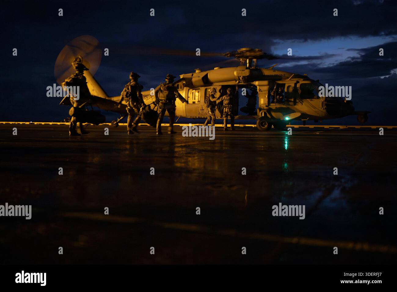 U.S. Coast Guard and Law Enforcement Tactical Team members, Sailors, and Marines prepare to board an MH-60S Sea Hawk helicopter, attached to Helicopter Sea Combat Squadron 9, from the flight deck of the world’s largest aircraft carrier, Ford-class aircraft carrier USS Gerald R. Ford (CVN 78) ahead of a right of visit boarding while underway in the Atlantic Ocean, Jan. 7, 2026. U.S. military forces are deployed to the U.S. Southern Command area of operations in support of the U.S. Southern Command mission, Department of War-directed operations, and the president’s priorities to disrupt illicit Stock Photo