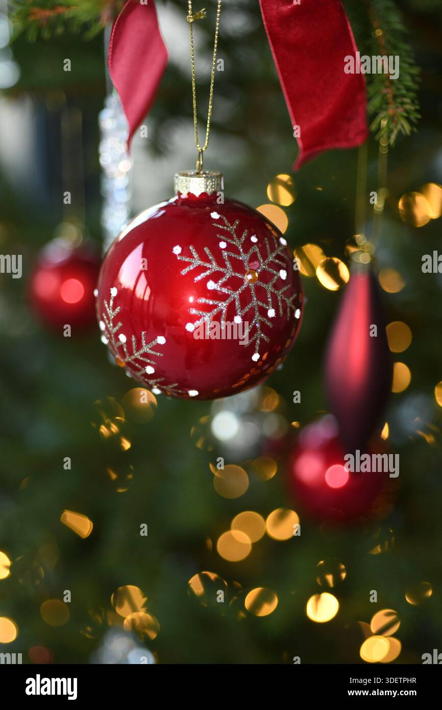 Red sparkly bauble on tree Stock Photo