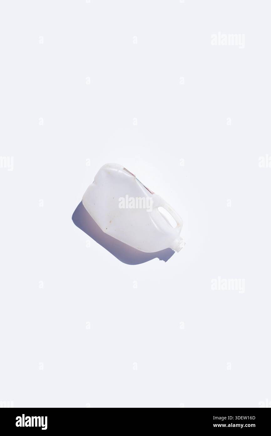 Discarded frosted plastic jug on solid white background Stock Photo