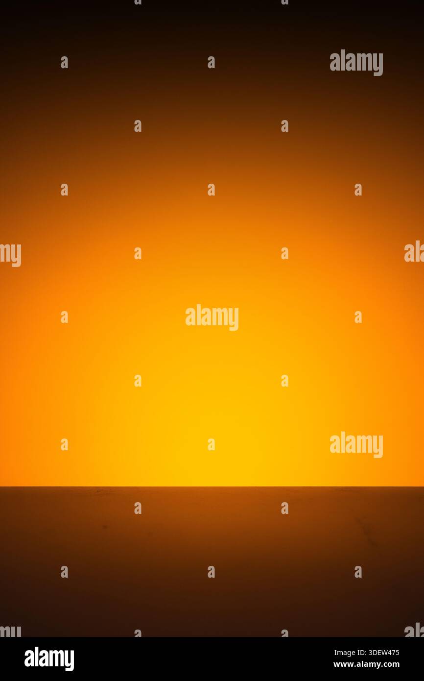 Abstract orange light glow on dark horizontal surface background. Stock Photo