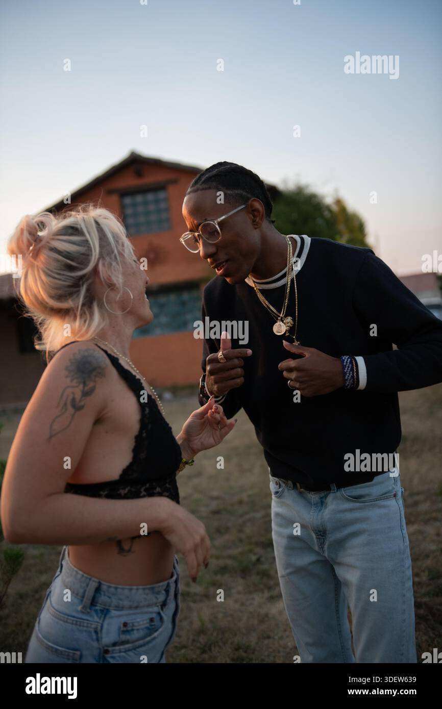 young couple dancing outside at sunset Stock Photo