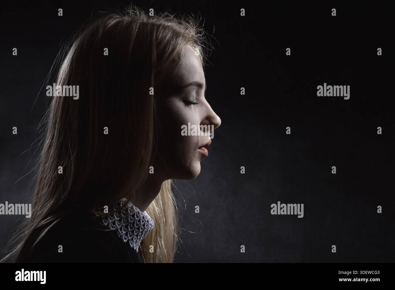 Sad girl crying on black background Stock Photo - Alamy