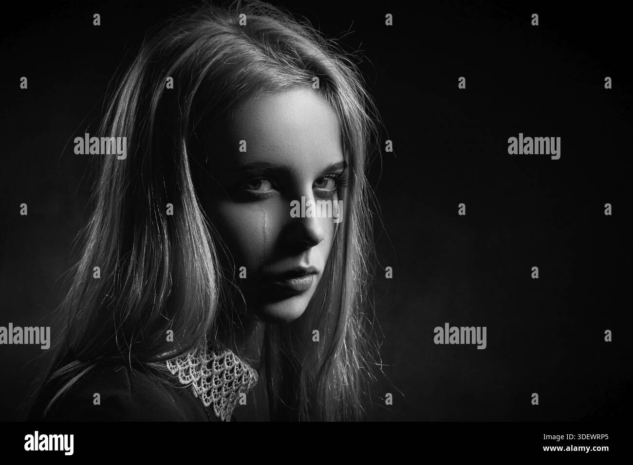 Sad girl crying on black background, monochrome Stock Photo - Alamy