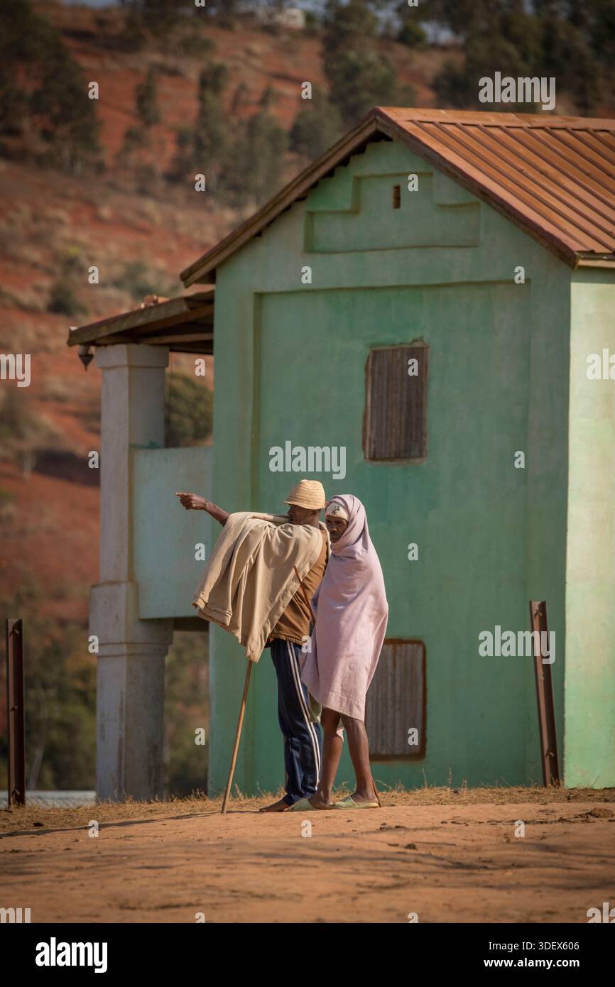 Malagasy men, wrapped in white cloths, one with a cane, at Ambalavao ...