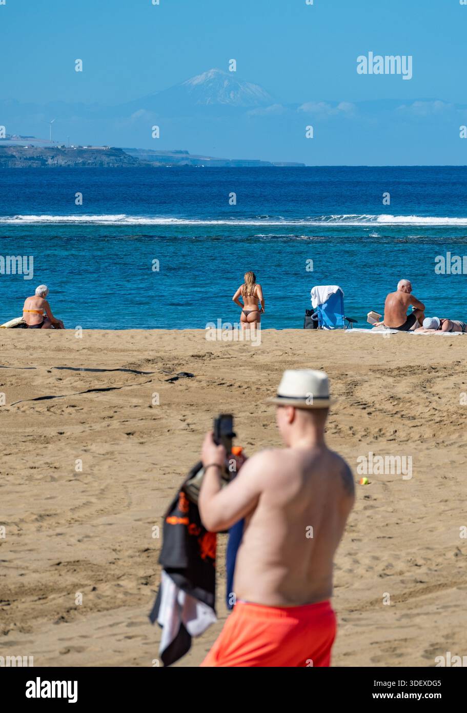 Las Palmas, Gran Canaria, Canary Islands, Spain. 9th January, 2026. Tourists, many British, bask in glorious sunshine on the city beach in Las Palmas on Gran Canaria as storm Goretti disrupts some flights back to the UK. PICTURED: View from the city beach in Las Palmas of a snow capped mount Teide (Spain's highest mountain) on the neighbouring island of Tenerife. Credit: Alan Dawson/Alamy Live News Stock Photo