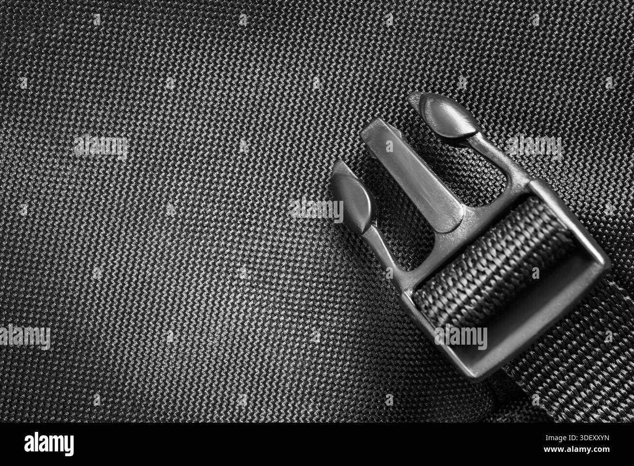 Black plastic fastex strap over black fabric background Stock Photo