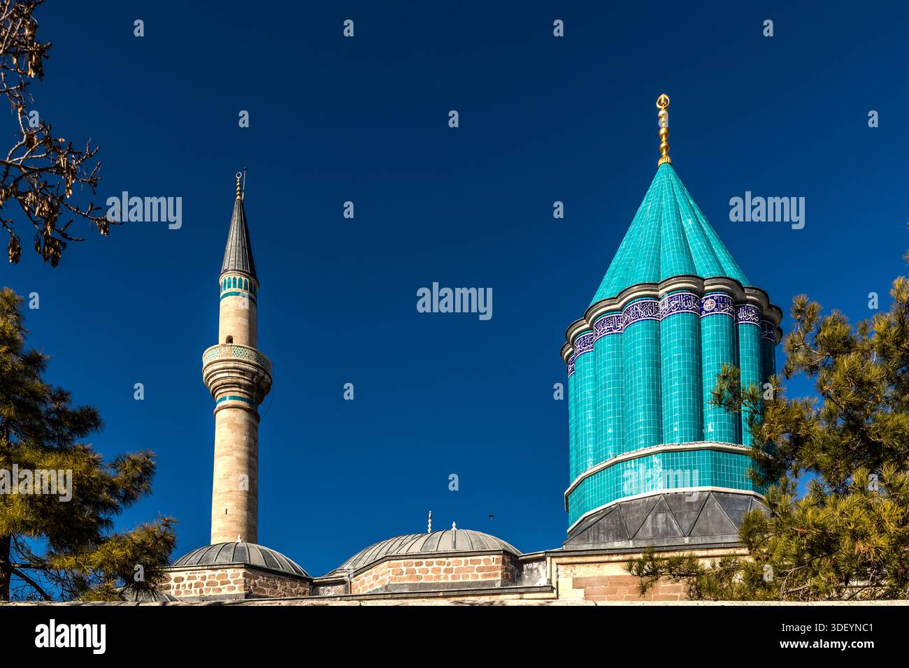 The Mevlana Museum (Mevlânâ Müzesi) in Konya-Karatay, Turkey, displays its green and golden domes and minaret in daylight. The museum is the mausoleum of the Sufi mystic Rumi (Jalāl ad-Dīn ar-Rūmī, 1207–1273), with an adjoining mosque and a former dervish cell; the turquoise dome above his tomb, dating from 1274, is regarded as the symbol of Konya. Stock Photo