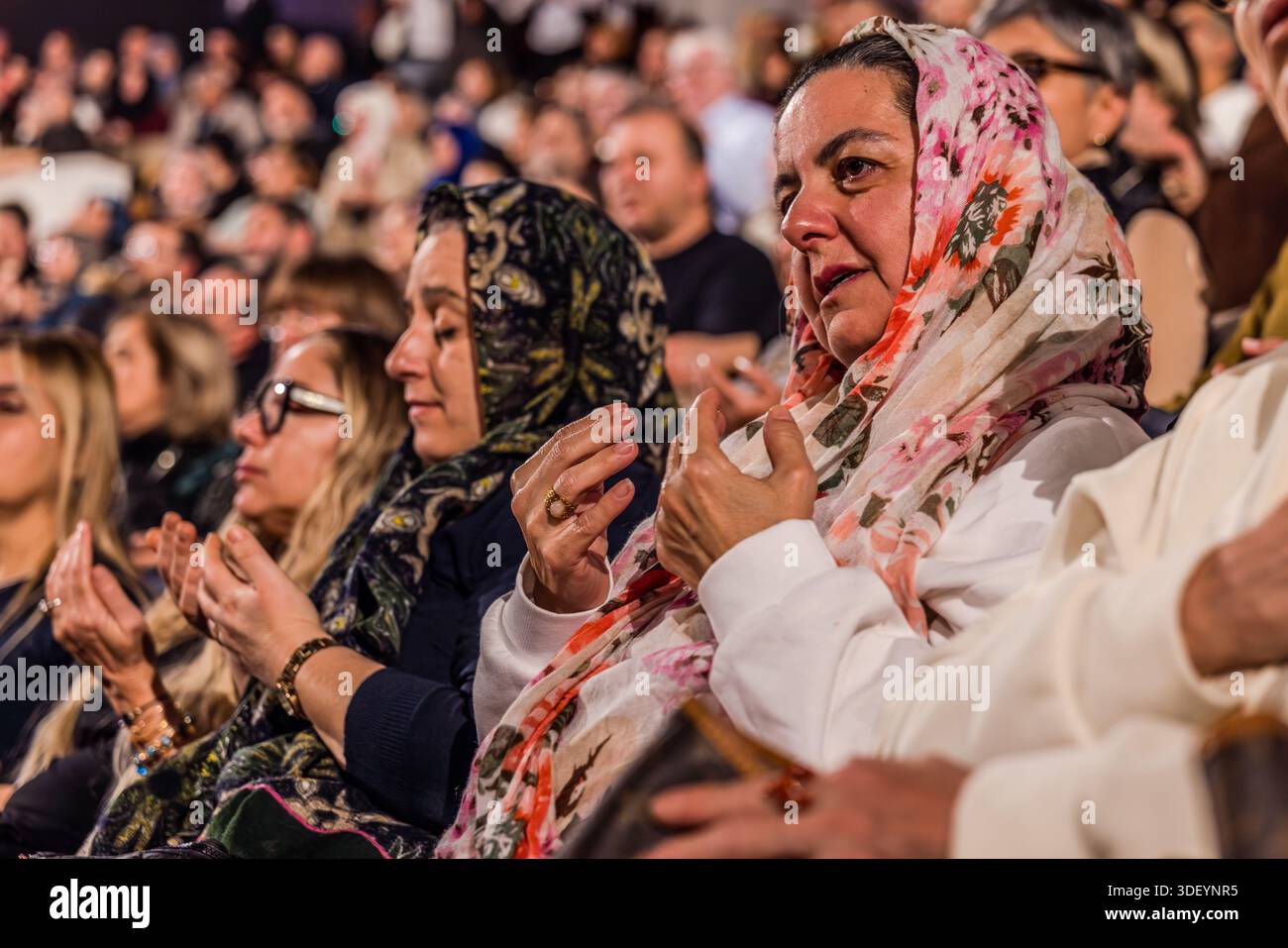 Şeb-i Arus ceremony in the Mevlana Kültür Merkezi, which can hold 3,000 people. Women wearing headscarves are moved at the end of the ceremony. Karatay, Konya, Central Anatolia Region, Turkey Stock Photo