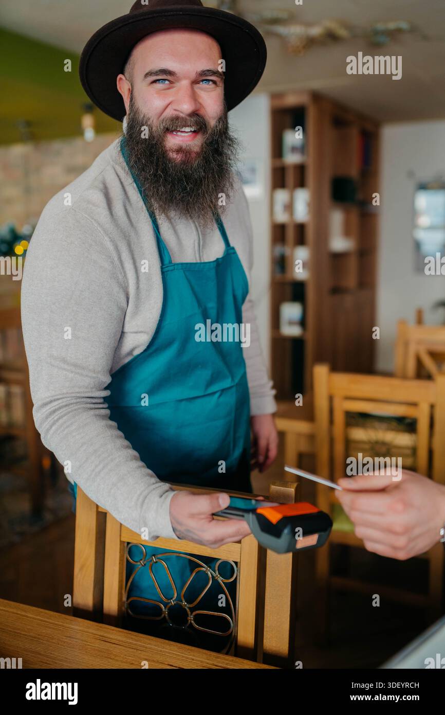 Smiling waiter taking payment from customer Stock Photo