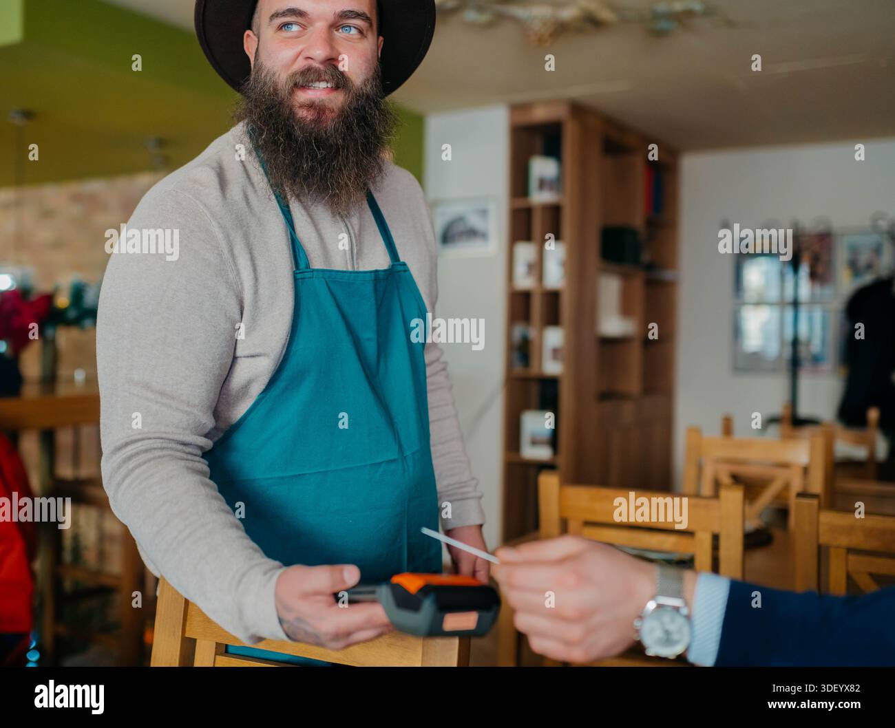 Smiling waiter taking payment from customer Stock Photo