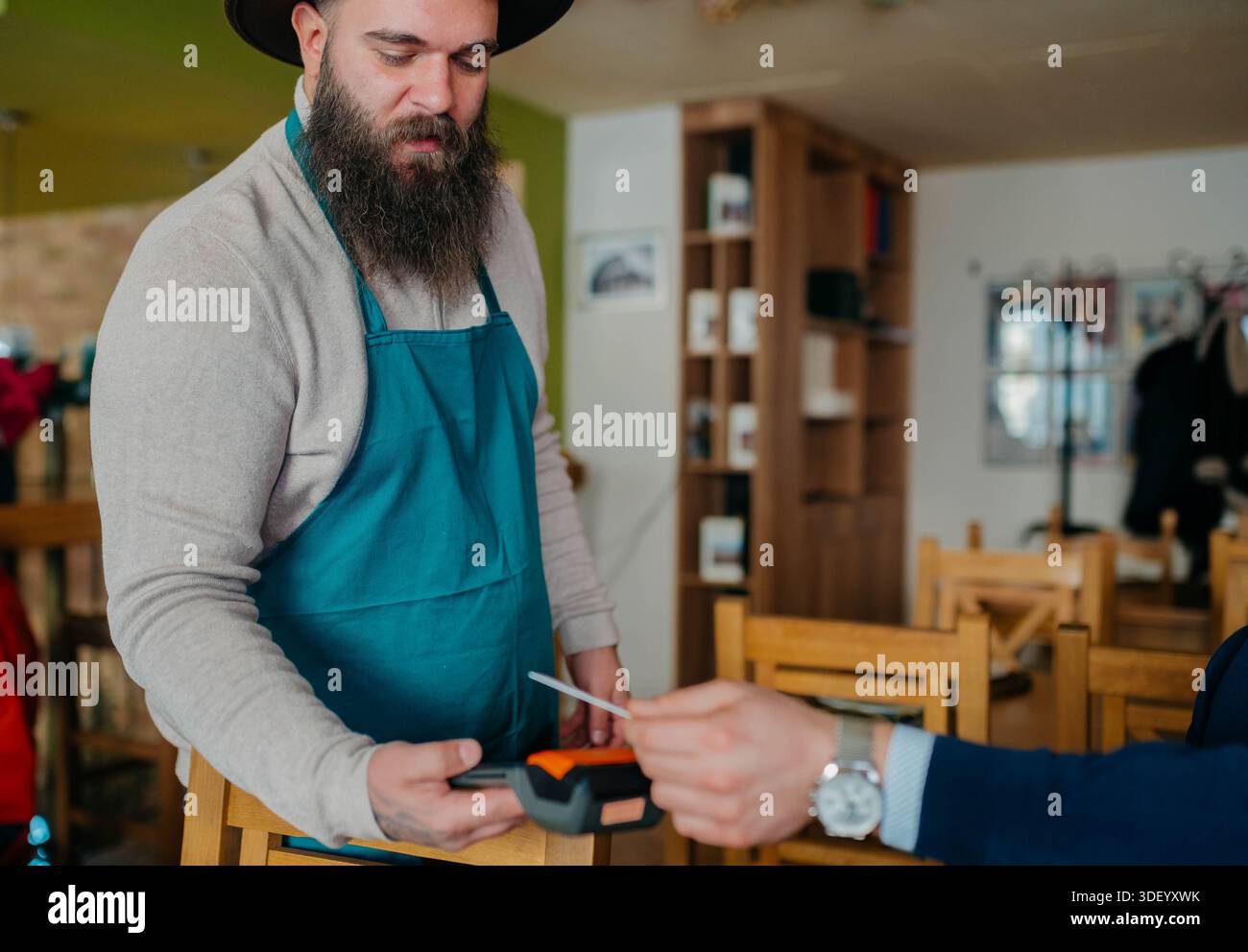 Smiling waiter taking payment from customer Stock Photo