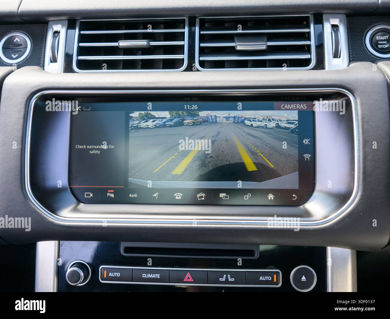 A car infotainment screen displays a rear view backup camera with ...