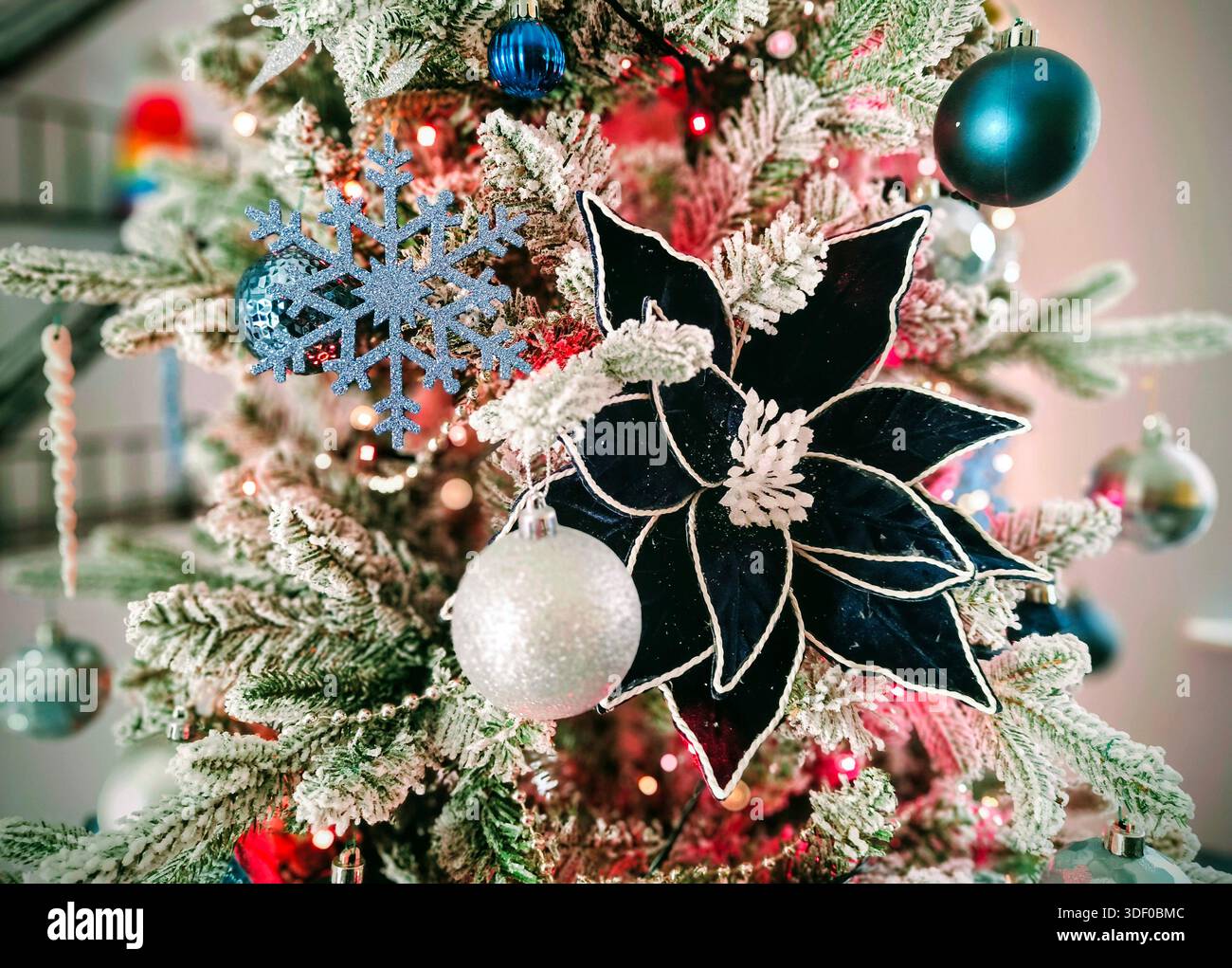 Christmas tree close-up with blue and silver baubles, blue flower, and blue glittery snowflake - Smartphone Captured Stock Image