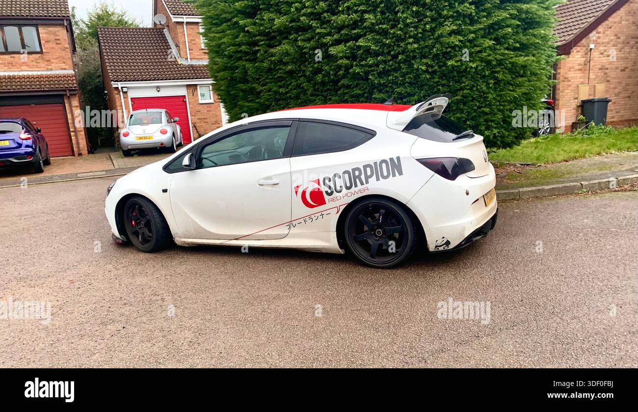 White sports hatchback with Scorpion performance decals and black alloy wheels parked on a residential street in Northampton Northamptonshire England - Smartphone Captured Stock Image
