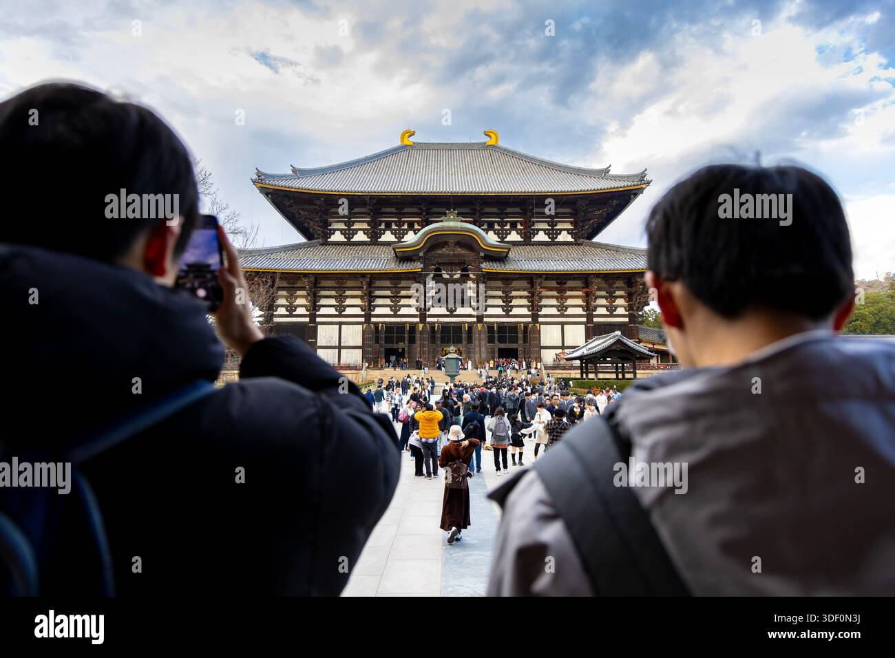 Tourists taking photos of the Kondo Hakkaku Toro of Todai-ji Temple, Nara, Japan Stock Photo