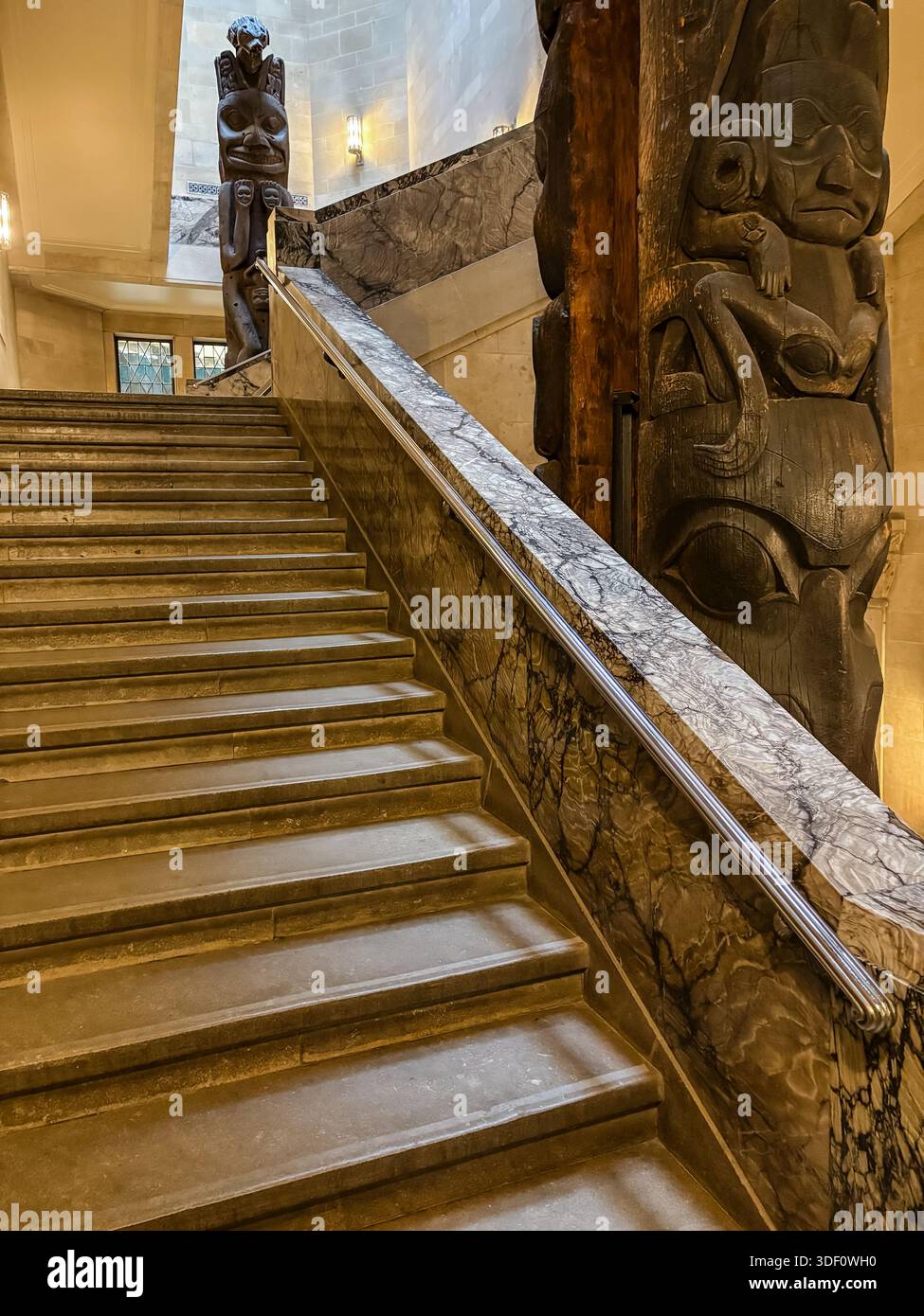 Royal Ontario Museum (ROM) Totem Pole Staircase in Toronto, Canada. Iconic interior featuring Kwakwakaʼwakw totem poles and grand marble stairs. Stock Photo