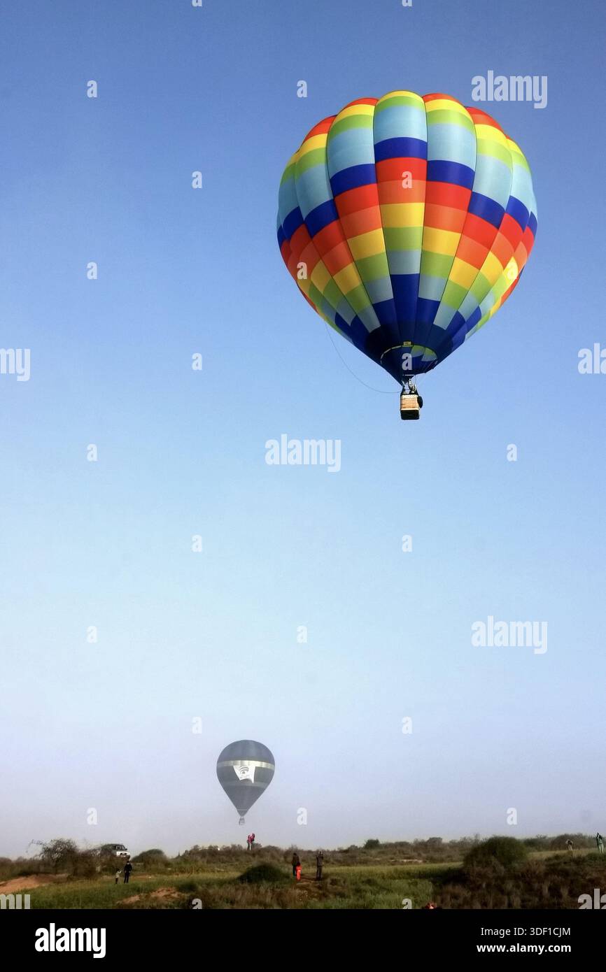 colorful hot air balloon floating high in a clear blue sky above an ...