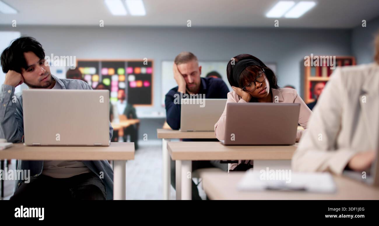Bored College Students Turn To Laptops In Classroom Study Session. Stock Photo