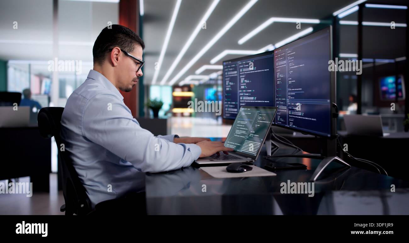 Hispanic Software Engineer Develops Program In Computer Office Workspace. Stock Photo