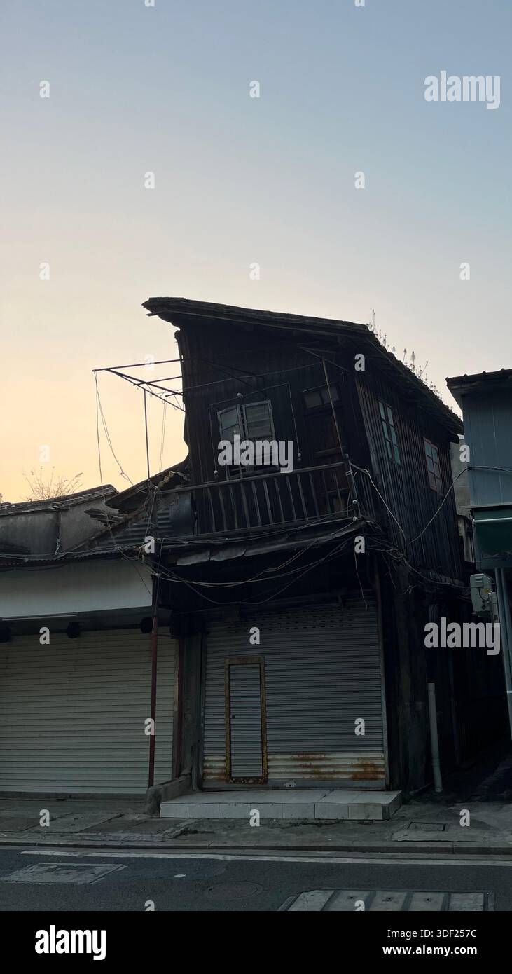 Old mixed use building with shuttered storefront in the old town, Shantou, Guangdong, China, showing everyday urban life and aging architecture. - Smartphone Captured Stock Image