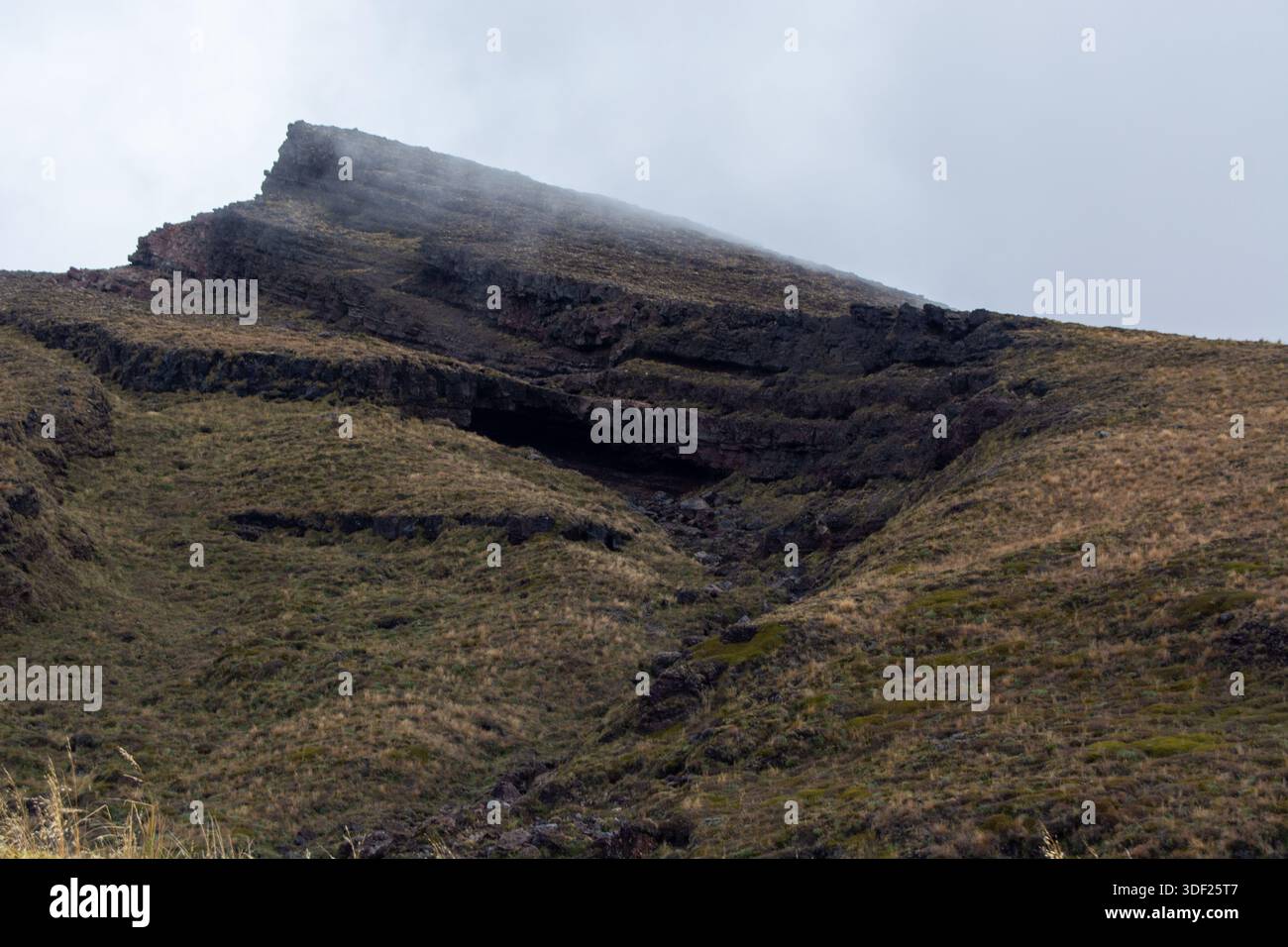A rugged mountain landscape featuring steep slopes and rocky outcrops ...