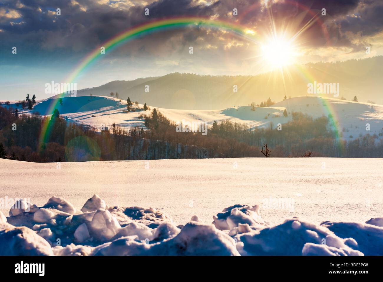 beautiful winter landscape with snow covered rolling hills under blue sky at sunset. majestic mountains in evening light. frosty countryside scenery. Stock Photo