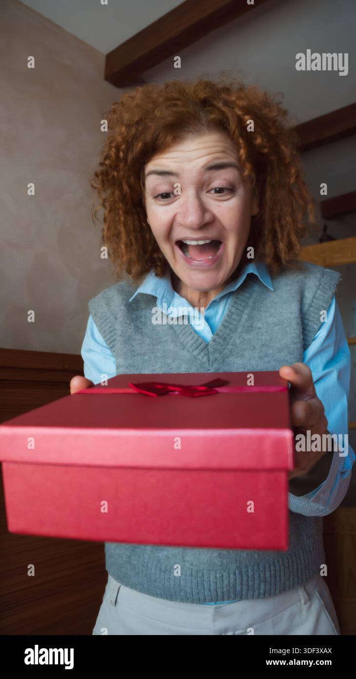 Woman expressing surprise receiving a red gift box Stock Photo